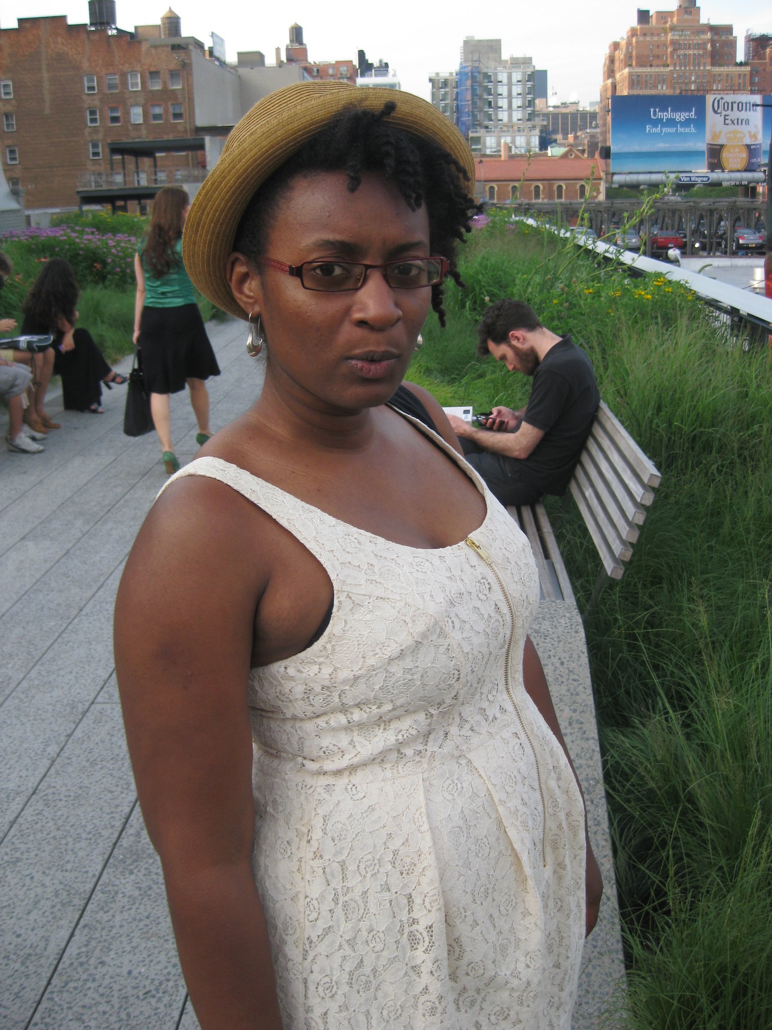 Dark skinned Caribbean & African American woman wearing a light colored lace dress