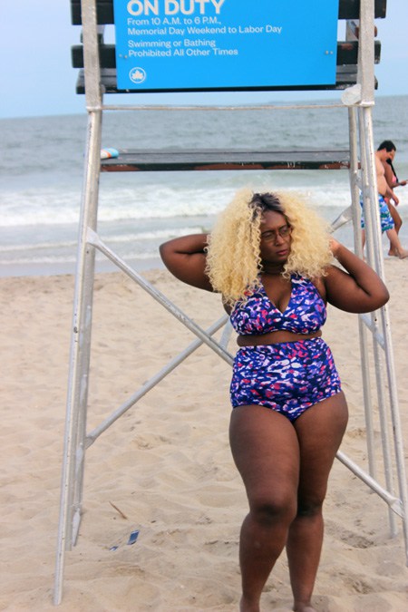 Dark skinned Caribbean & African American woman wearing a high waisted purple bikini.